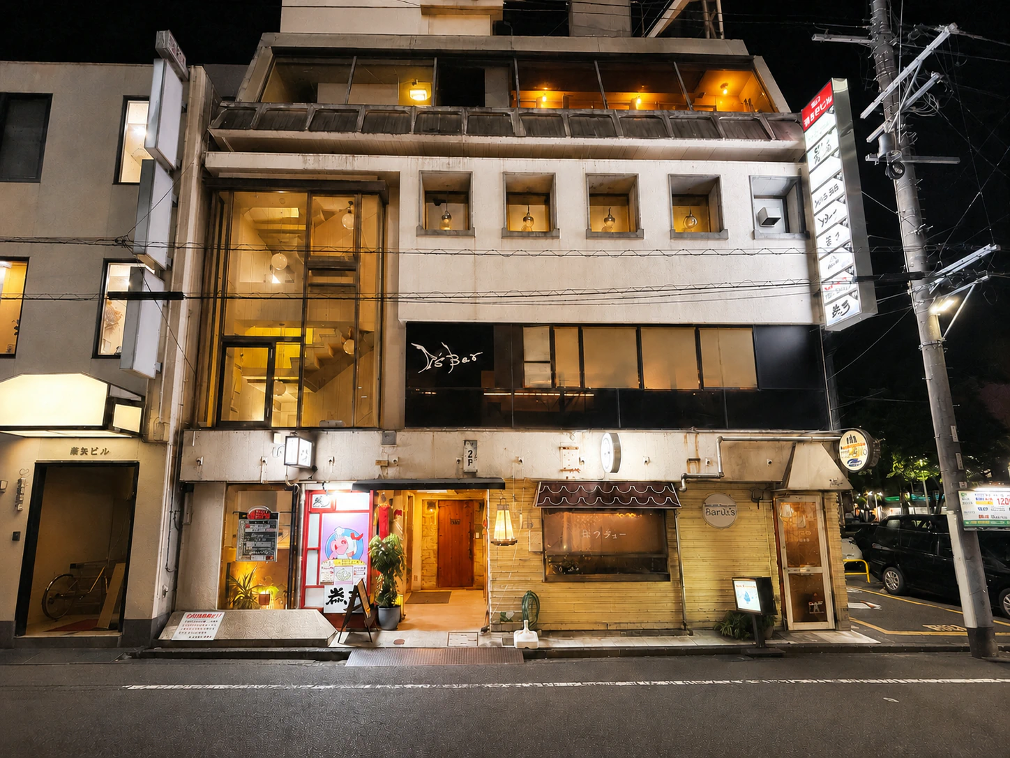 夜の通りに灯りがともる空道の入る建物
